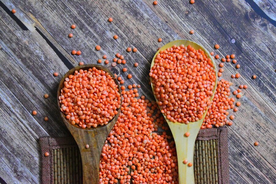 Wooden board of lentils, wholegrains and seeds in natural light, high-fibre plant variety for gut health