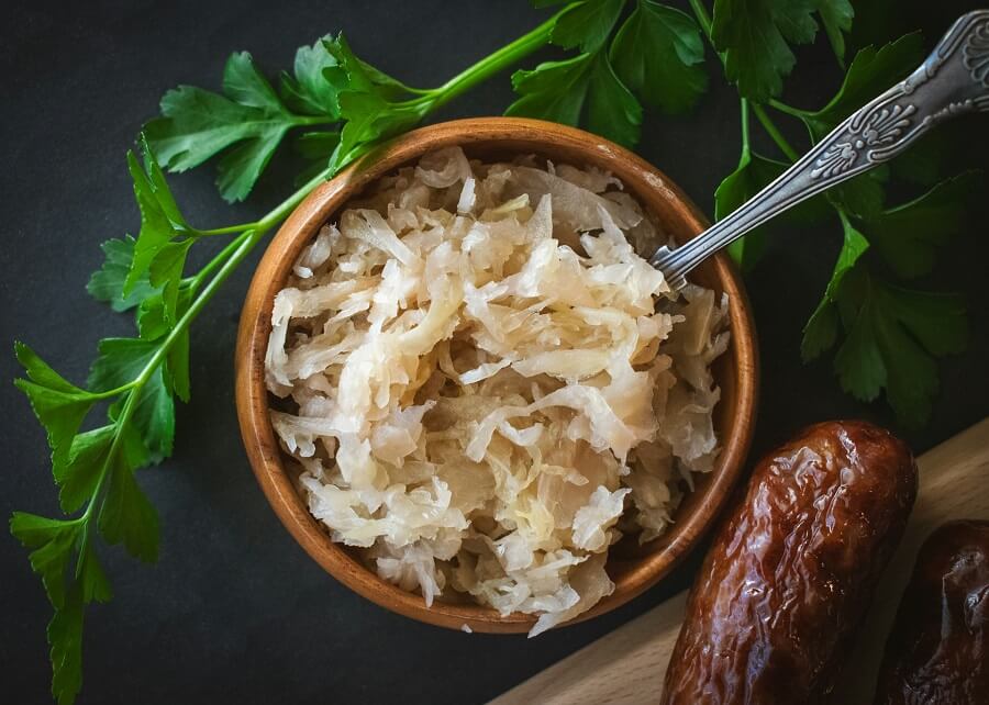 Open jar of raw unpasteurised sauerkraut on a kitchen counter in daylight, live fermented food for gut health