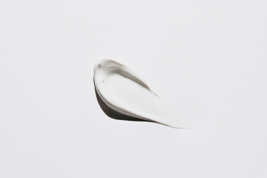 One amber glass serum bottle on a stone surface in window light, the short Healthy Skin shelf