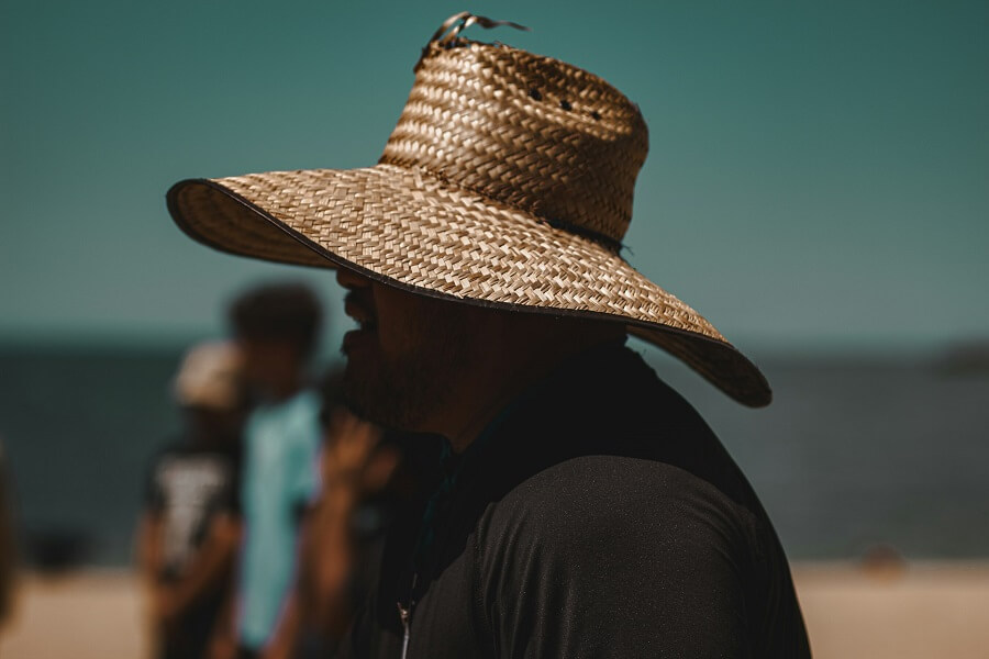 Straw sun hat on a wooden table in bright daylight, daily sun protection for Healthy Skin