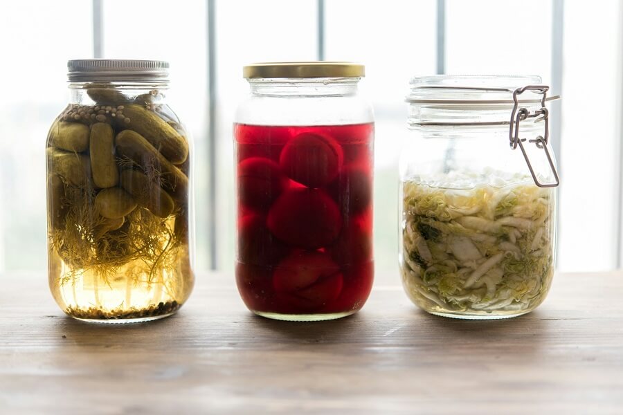 Jar of sauerkraut on a wooden board in kitchen daylight, fermented foods for Support Immunity