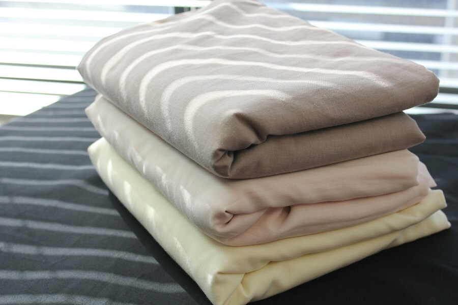 Close detail of organic cotton clothing fabric weave in natural light.