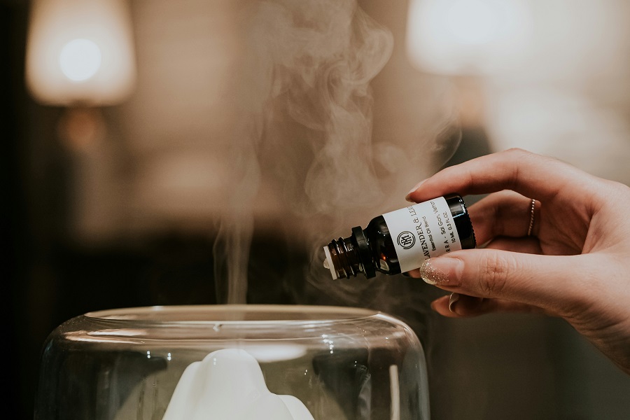 Refilling a reed diffuser from a refill bottle in natural daylight