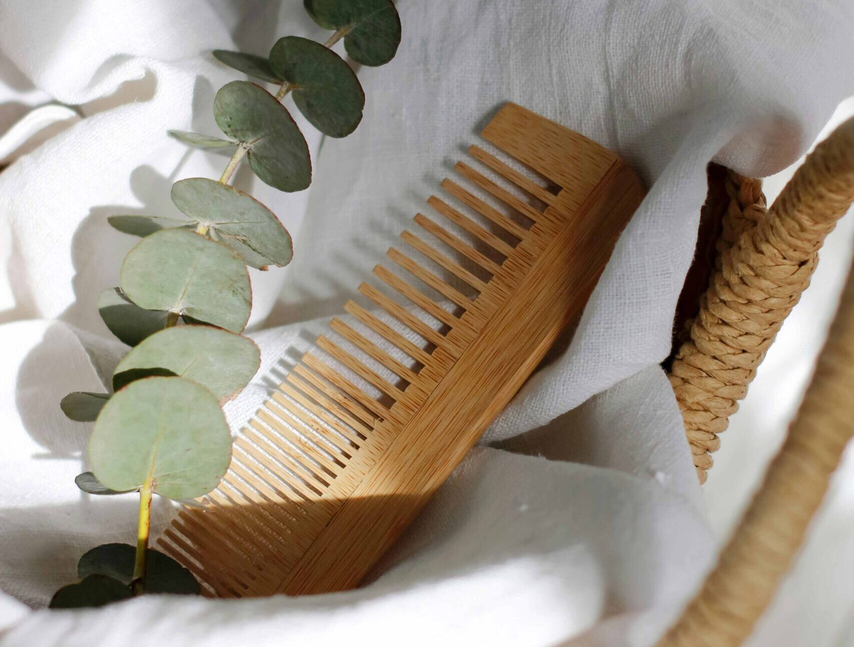 Worn wooden comb on a wooden surface in natural light, used for beard grooming